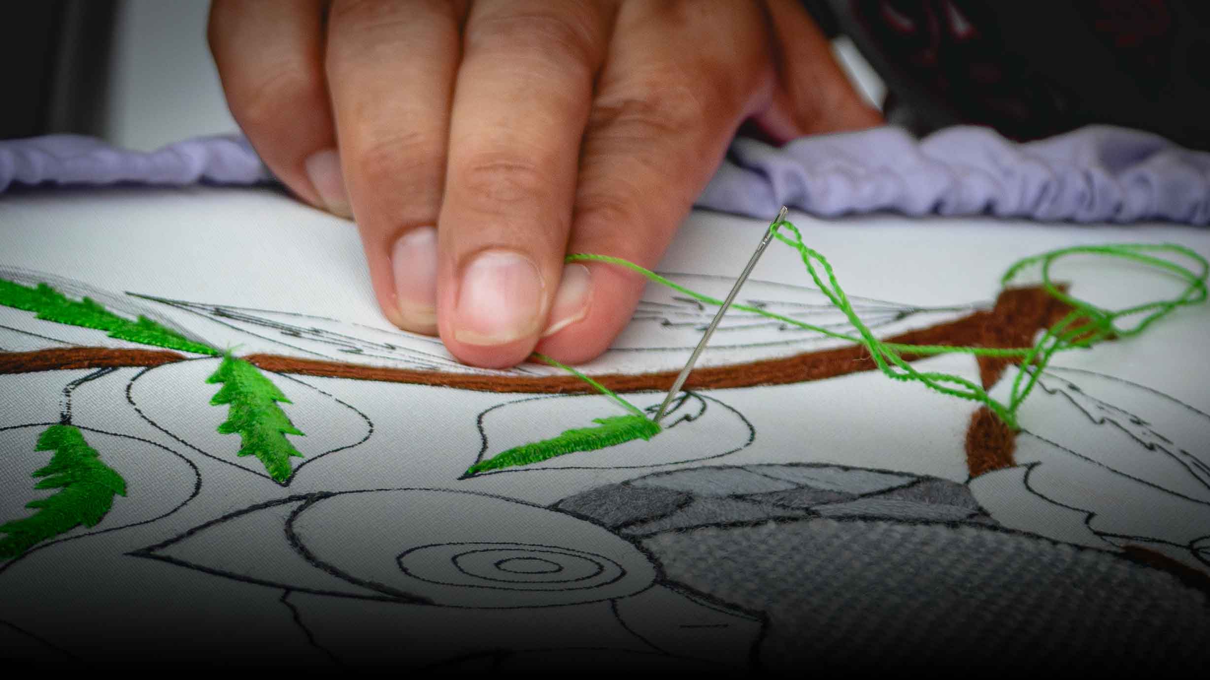 Manos trabajando en un bordado durante un taller creativo